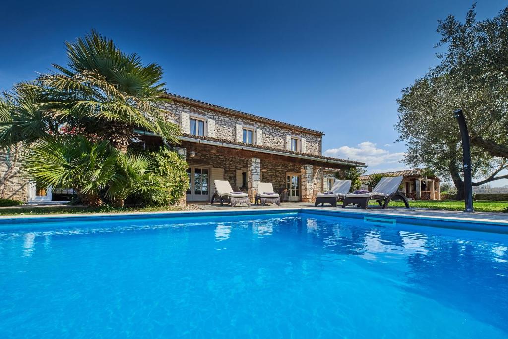 a large blue swimming pool in front of a house at Villa Rea in Umag