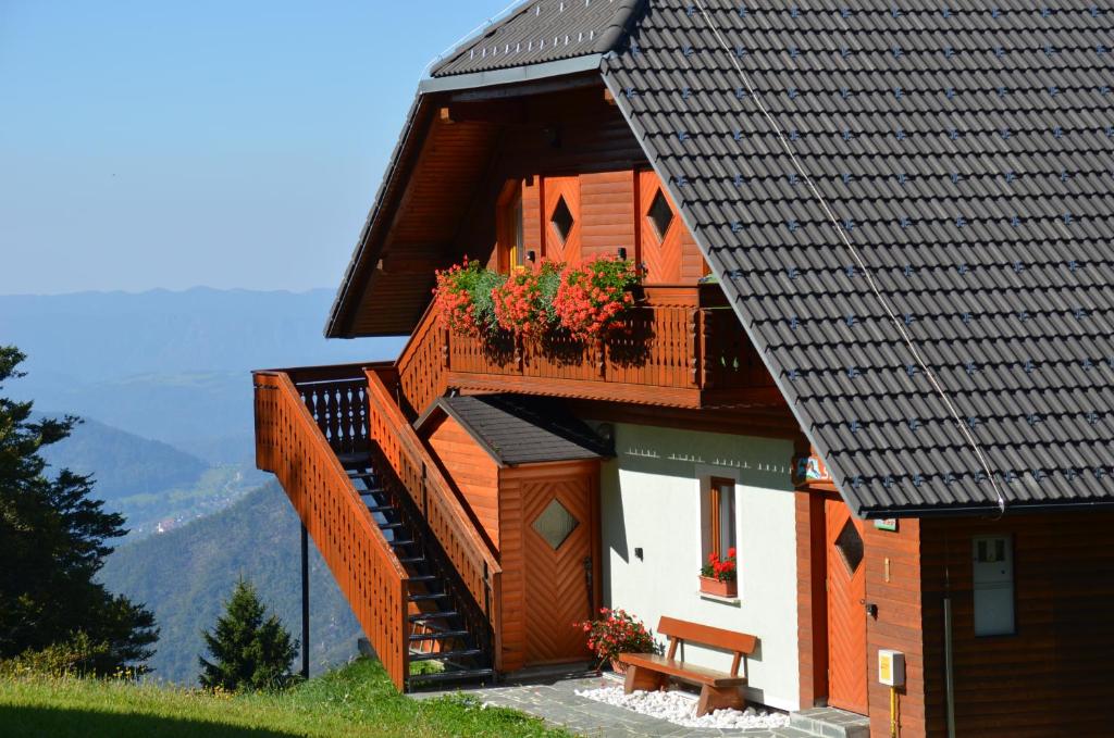 a house with a balcony with flowers on it at Apartmaji Srnca in Cerkno