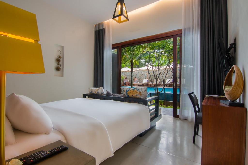 a bedroom with a bed and a view of a pool at Apsara Residence Hotel in Siem Reap
