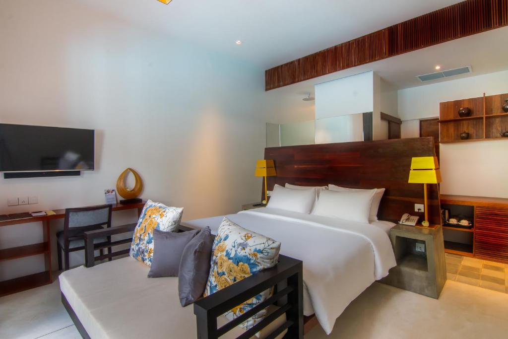 a bedroom with a large white bed and a desk at Apsara Residence Hotel in Siem Reap