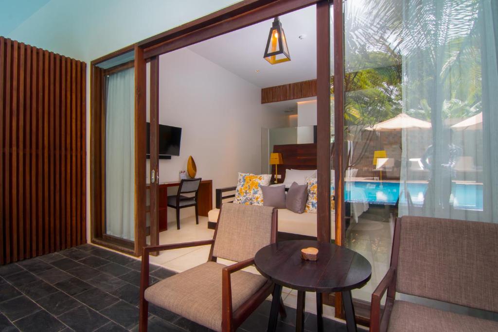 a living room with a table and a room with a pool at Apsara Residence Hotel in Siem Reap