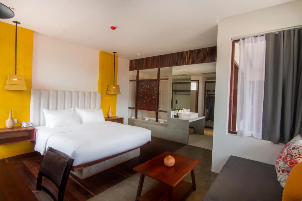 a bedroom with a white bed and a living room at Apsara Residence Hotel in Siem Reap