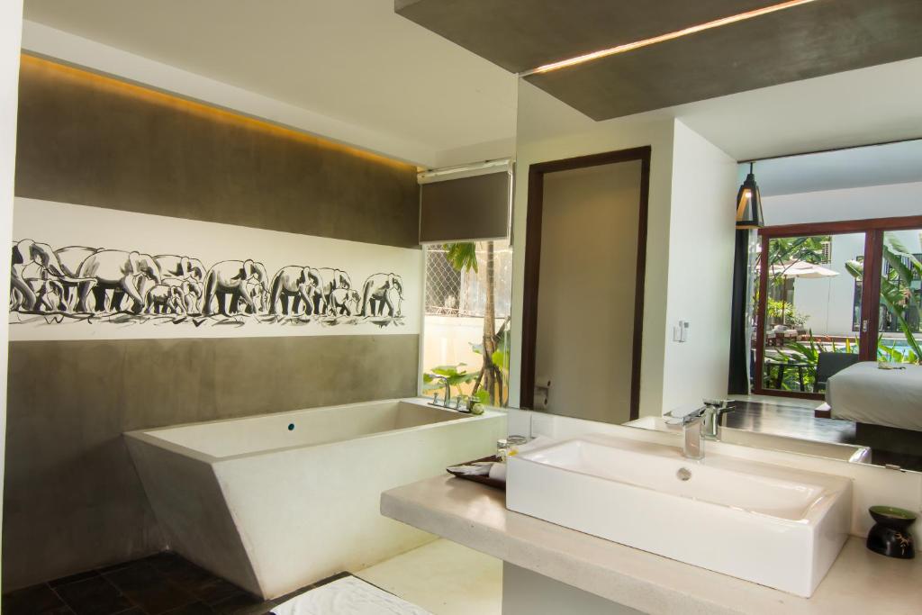 a bathroom with a large white tub and a sink at Apsara Residence Hotel in Siem Reap