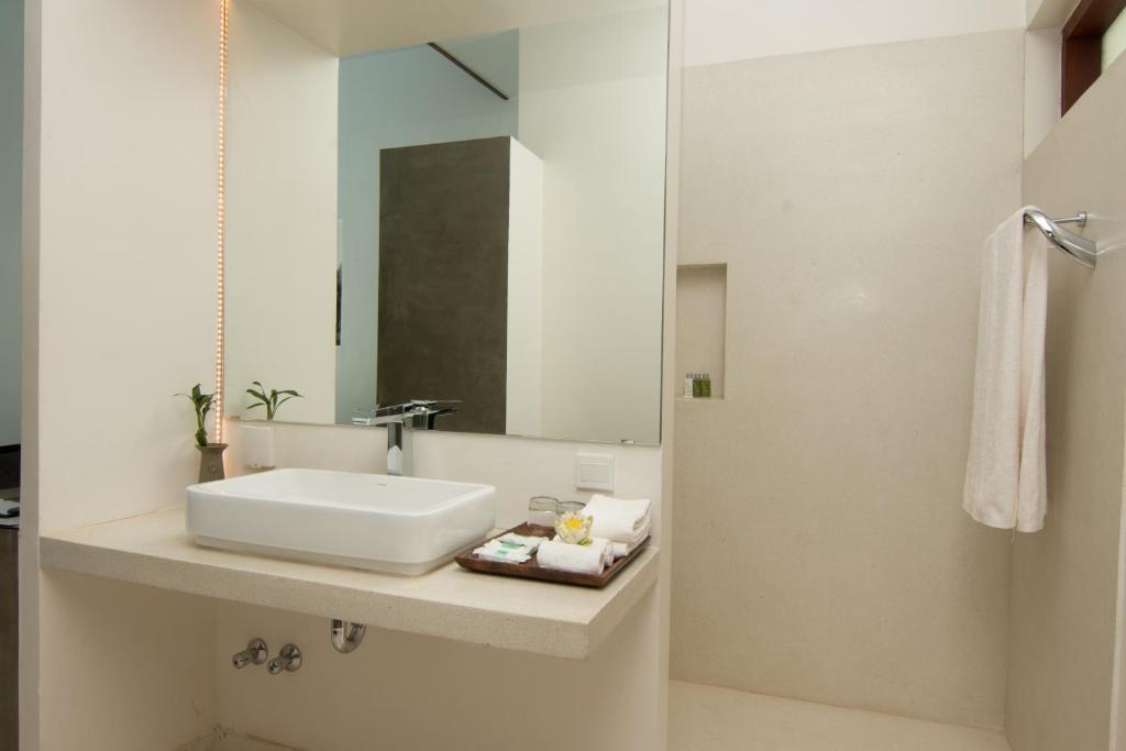 a white bathroom with a sink and a mirror at Apsara Residence Hotel in Siem Reap