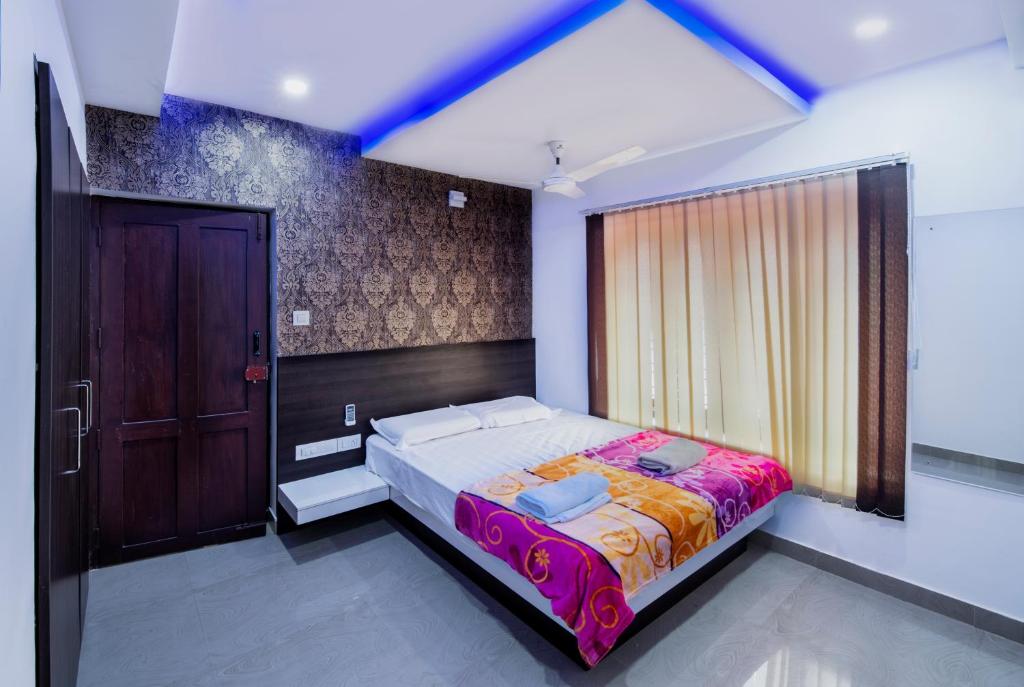 a bedroom with a bed and a window and a door at Rams Guest House Near Sree Chithra and RCC in Trivandrum