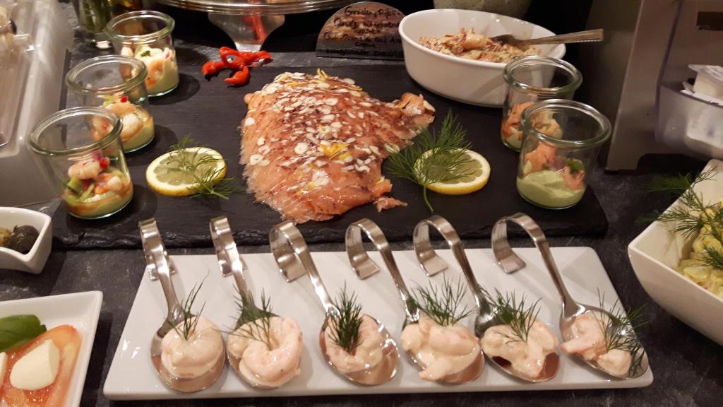 a table with forks and oysters and other foods at Hotel Central in Erlangen