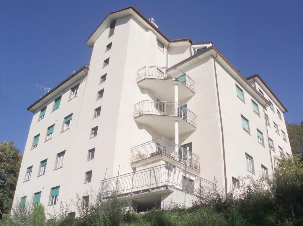 - un bâtiment blanc avec des balcons sur le côté dans l'établissement Albergo Villa Margherita, à Tiglieto