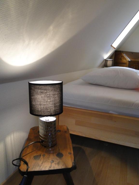 a bedroom with a bed and a table with a lamp at Le Loft a La couronne centre ville de Barr in Barr