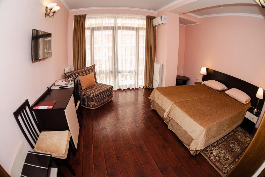 a bedroom with a bed and a desk and a chair at Guest House BoNaMi in Anapa