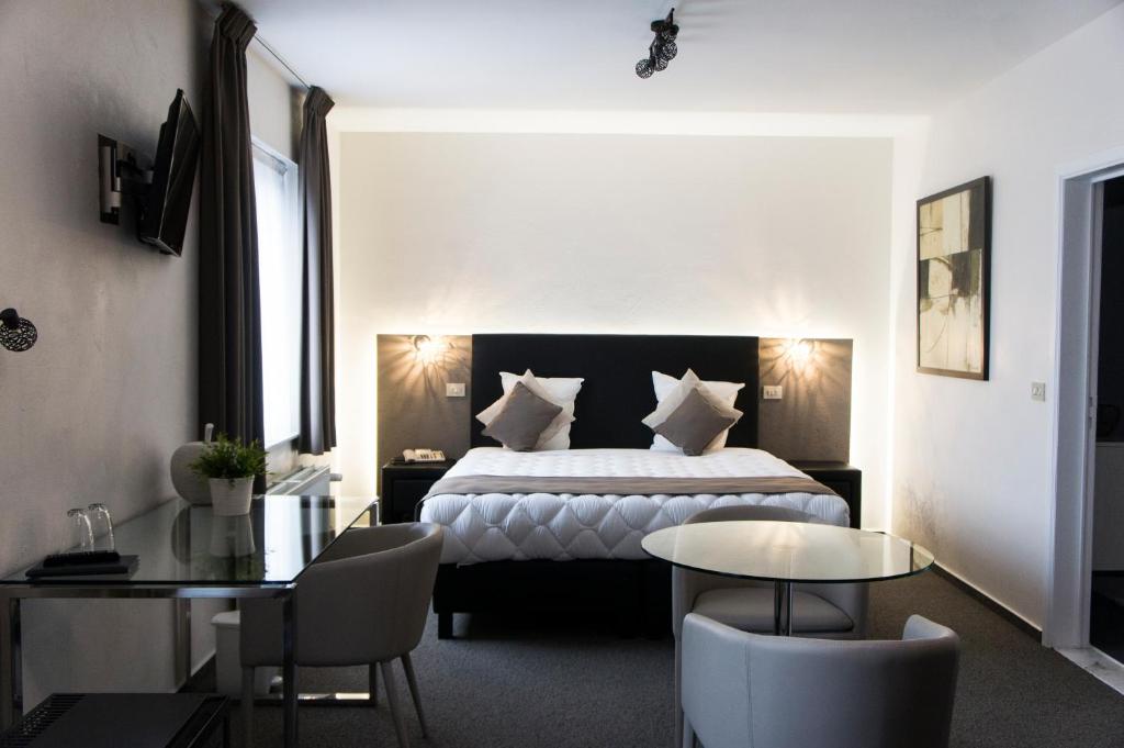 Habitación de hotel con cama, mesa y sillas en Hotel Adoma, en Gante