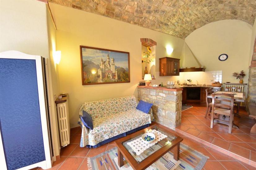 un soggiorno con divano e tavolo di Casa Vacanze Vertine a Gaiole in Chianti