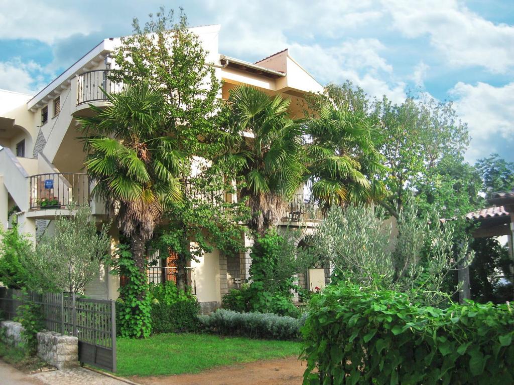 un edificio con una palmera delante de él en Apartments Marija en Sukošan