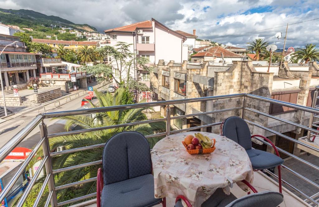 a table with a bowl of fruit on a balcony at Apartmani Spaic in Herceg-Novi