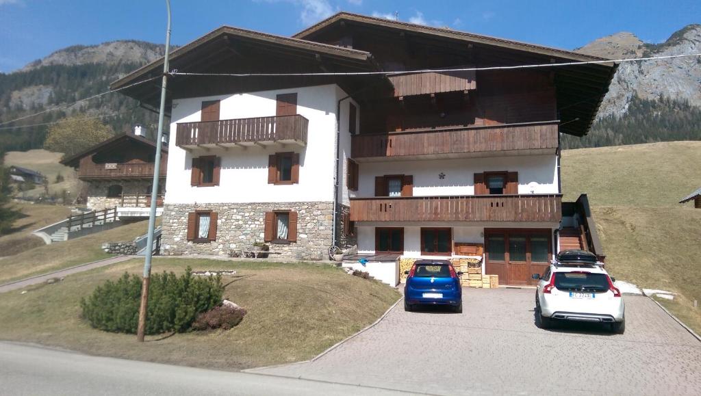 a house with two cars parked in front of it at Appartamento Lanner in Sappada