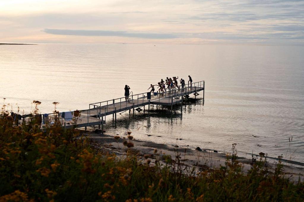 Un groupe de personnes debout sur une jetée au-dessus de l'eau dans l'établissement Musholm Holiday, Sport & Conference, à Korsør