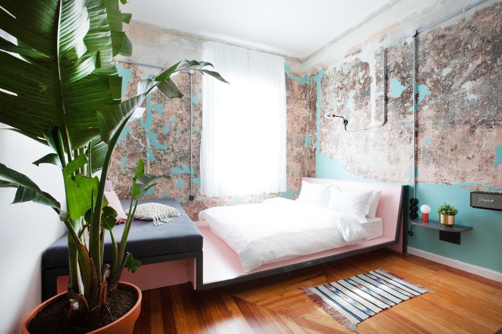 a bedroom with a white bed and a potted plant at The Trilogy House in Thessaloniki