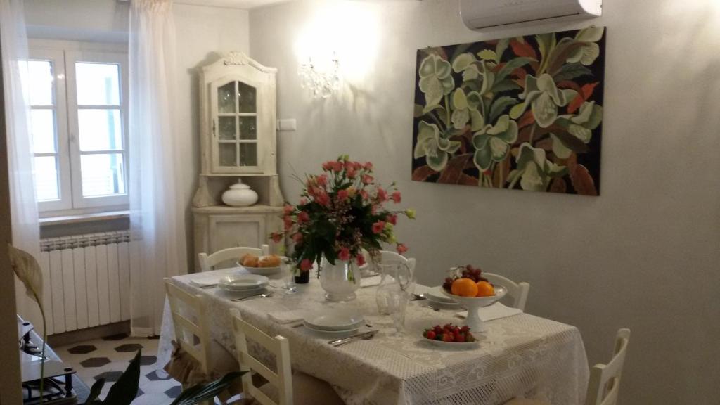 a dining room table with a white table cloth and flowers at Luxury apartment Suite La Fontana in Lucca