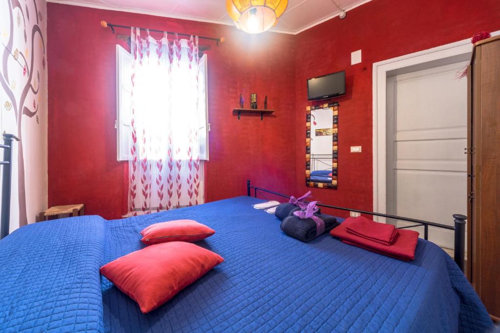 a bedroom with a blue bed with red walls at Casa sul Corso in Trapani