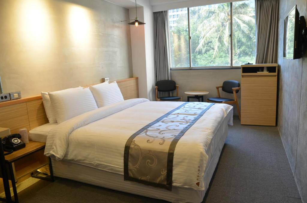 a hotel room with a large bed and a window at Atami Hotel in Taipei