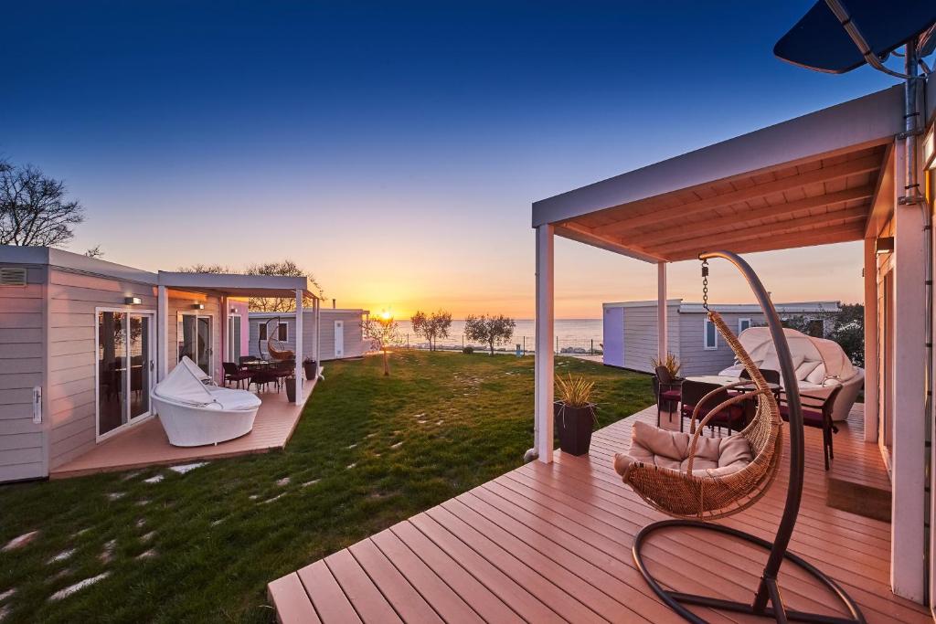 een terras met een hangmat en stoelen op een huis bij Mobile Homes Sunset Beach in Umag