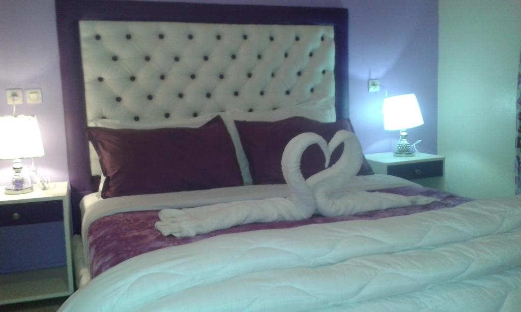 d'un lit avec deux cygnes blancs posés sur lui dans l'établissement Hotel School Ersat Azrou, à Azrou