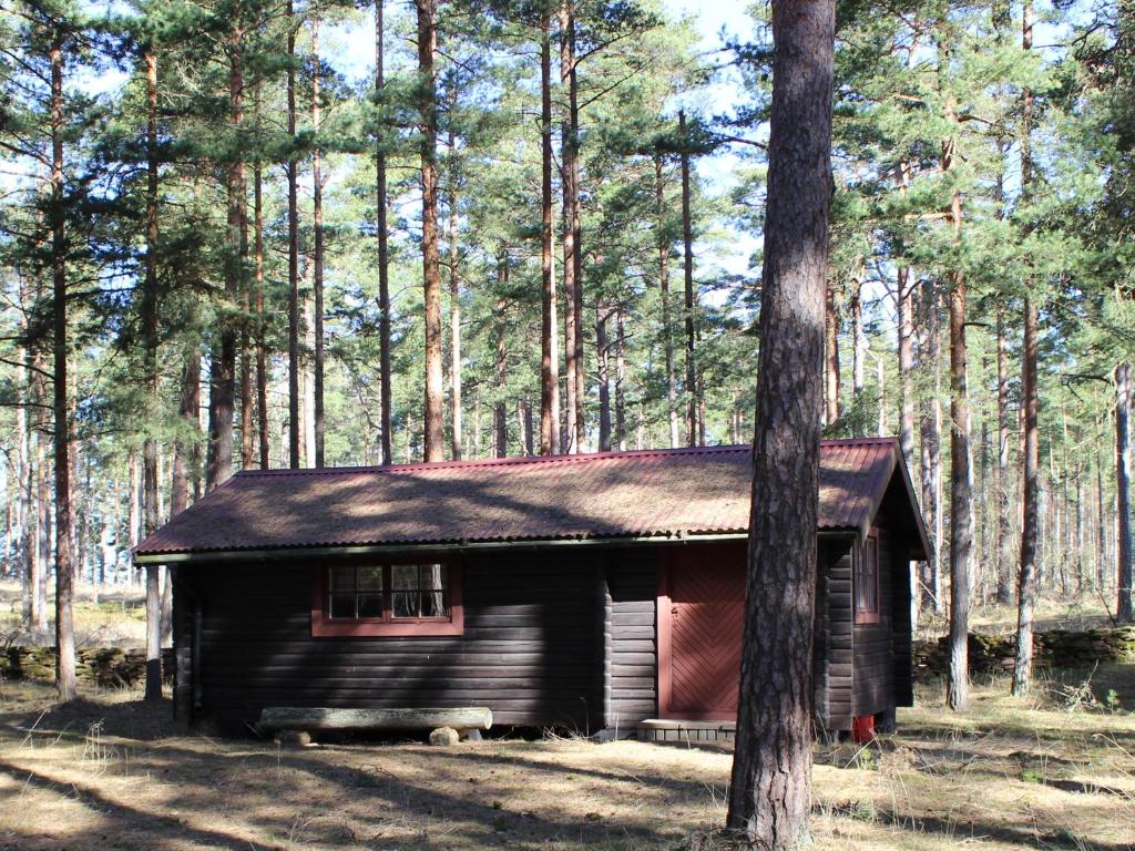 uma pequena cabana na floresta ao lado de uma árvore em Byron em Rälla