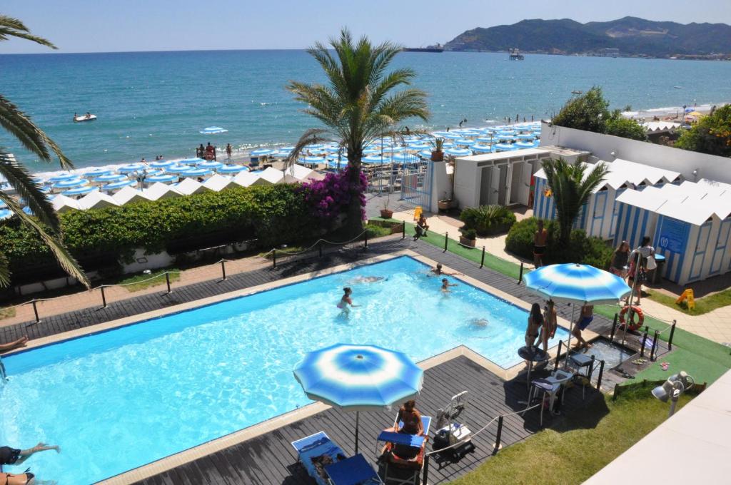 a swimming pool with the ocean in the background at Hotel Miramare in Savona