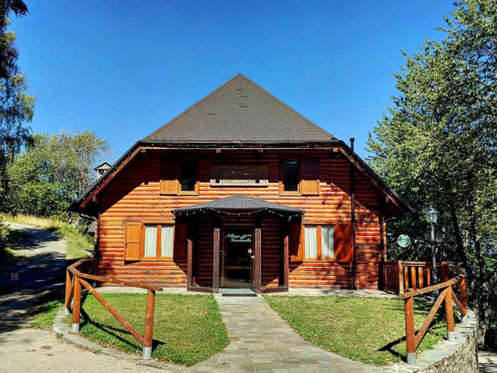 uma cabana de madeira com uma porta em frente em Albergo Genzianella em Careggine