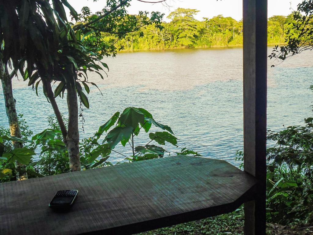a remote control sitting on a bench next to a body of water at Tambopata River in Puerto Maldonado