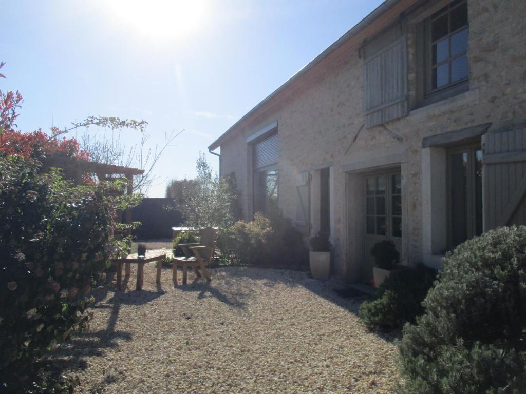 un patio de una casa con una mesa y un banco en la grange aux hirondelles, en Sancoins