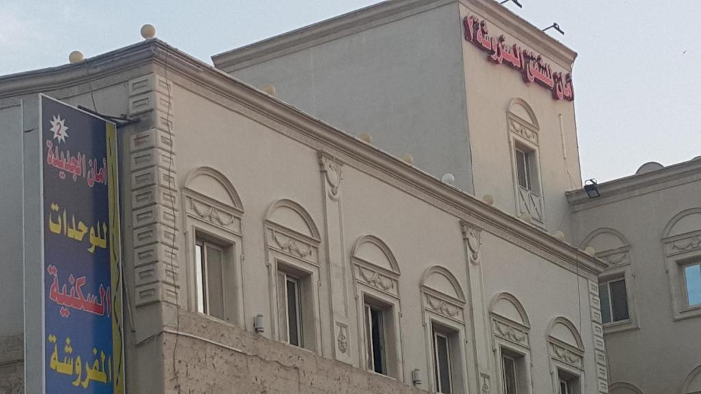 un edificio blanco con un cartel encima en Aman Furnished Apartments 2, en Yeda