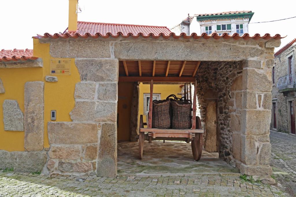 a wooden bench in front of a stone building at Curral de l Tiu Pino in Sendim