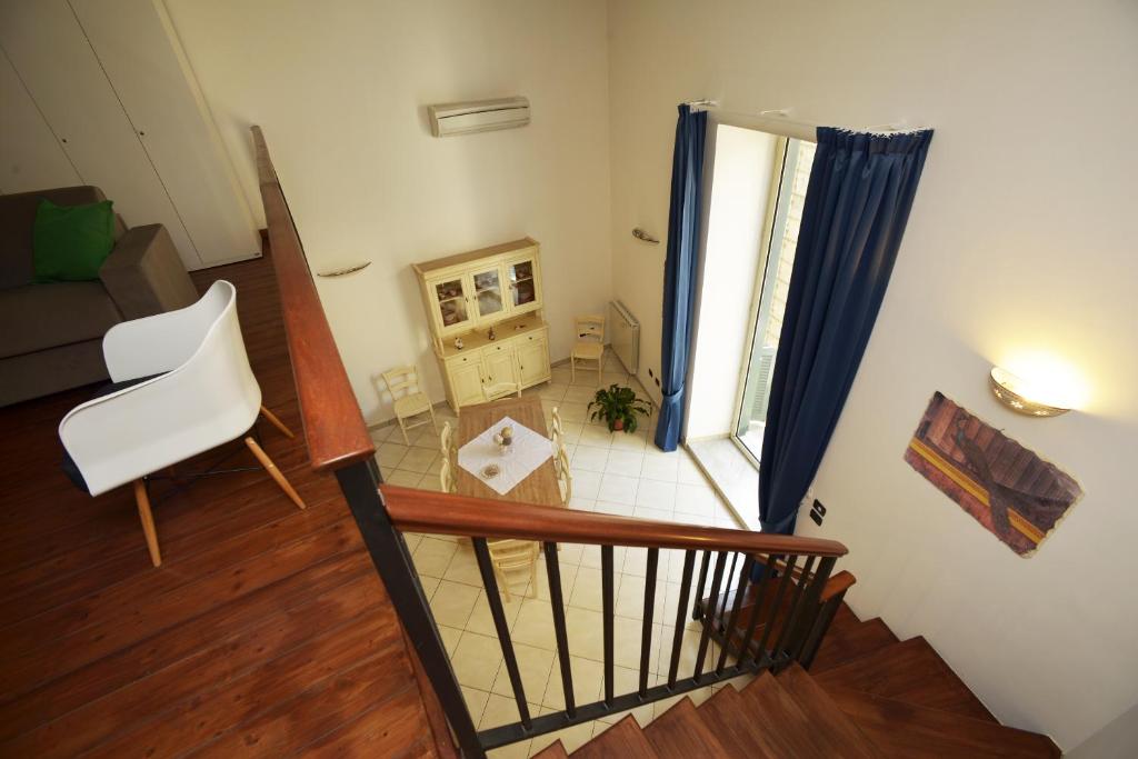 Italia Apartment في نابولي: إطلالة على غرفة معيشة مع درج وغرفة مع نافذة