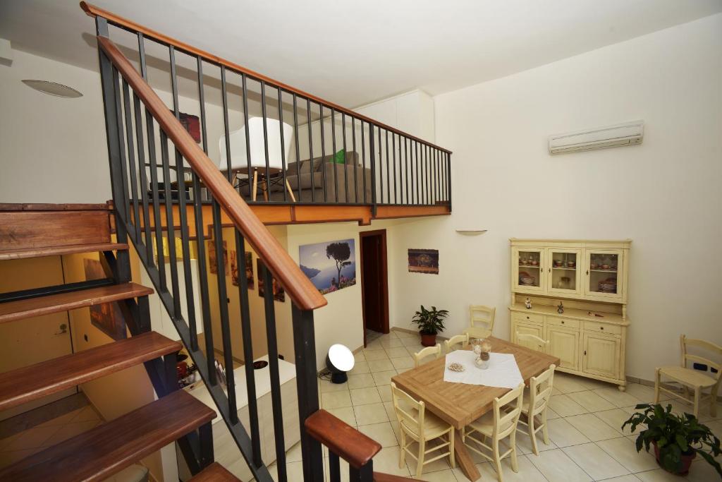 un soggiorno con tavolo e scala di Italia Apartment a Napoli