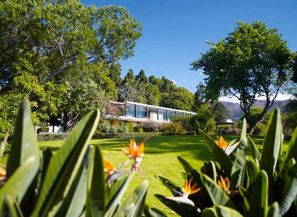 une maison dans un champ avec des fleurs au premier plan dans l'établissement Quinta da Casa Branca, à Funchal