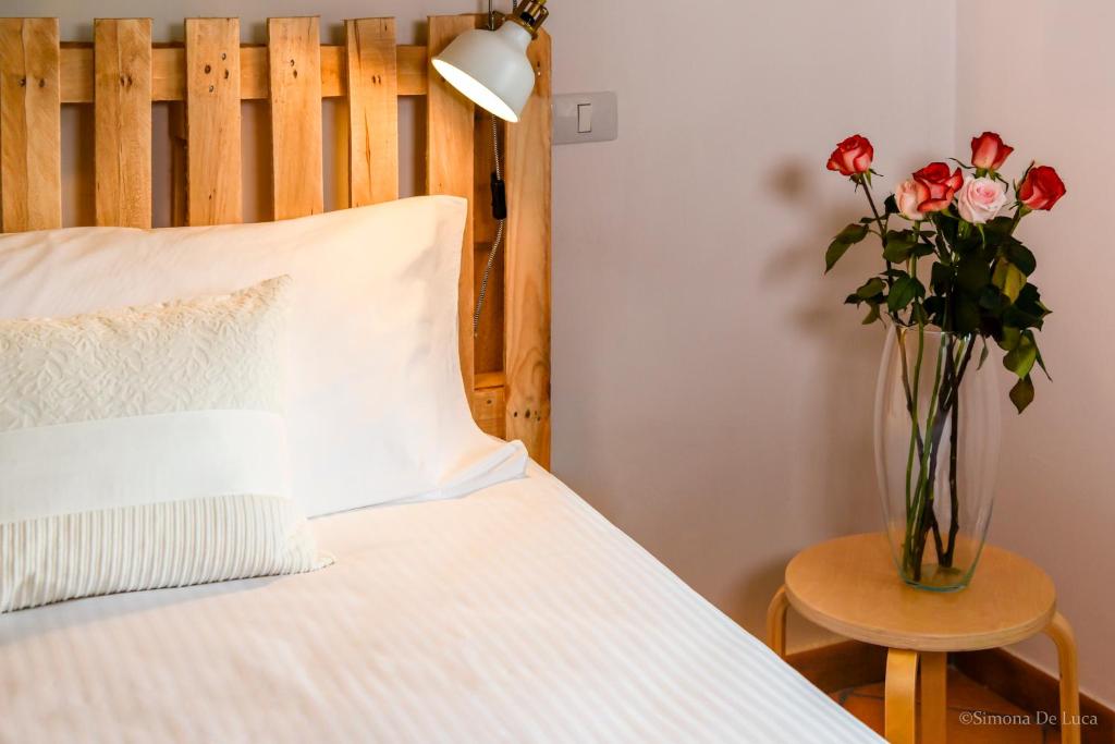 a bedroom with a bed with a vase of roses at Bonjour Bonheur in Avellino