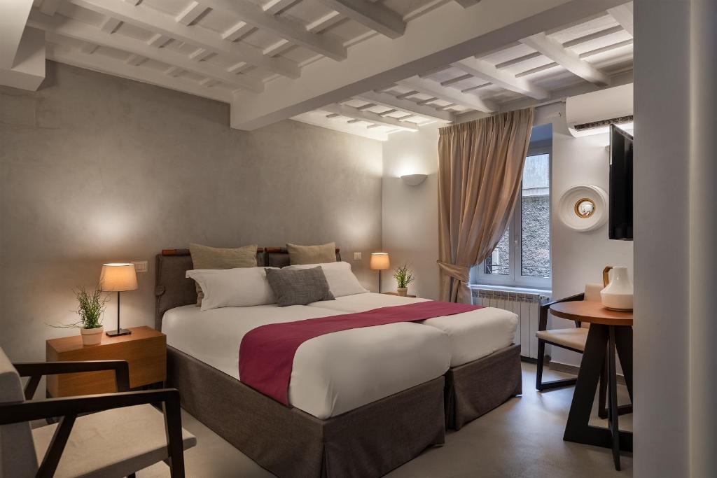 - une chambre avec un grand lit et une fenêtre dans l'établissement The Spanish Suite Piazza di Spagna, à Rome