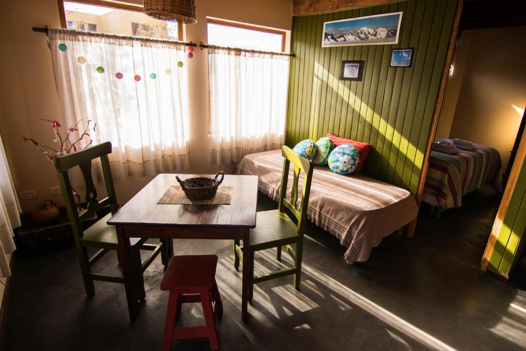 a room with a table and a bed and a table and chairs at Casa Andina Chaltén in El Chalten