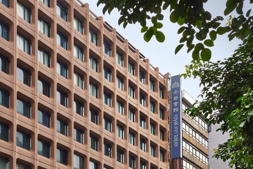 um edifício castanho com uma placa em frente em Royal Inn Taipei Nanxi - MRT Zhongshan Station em Taipei