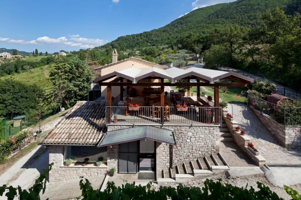 una casa en la cima de una colina con un edificio en Agriturismo il Castello en Asís