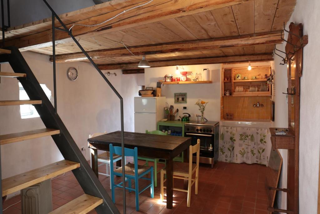 una cucina con tavolo, sedie e frigorifero di Casa Acquarossa a Rubiana