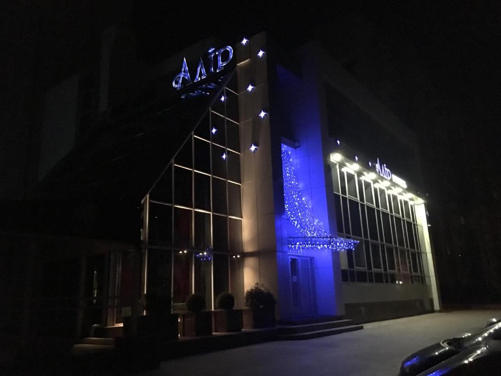 ein großes Gebäude mit blauem Licht in der Nacht in der Unterkunft Alir in Schytomyr
