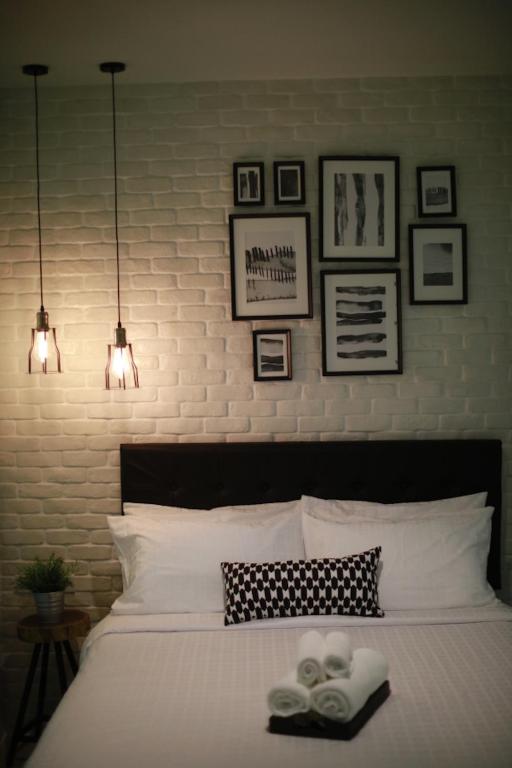 a bedroom with a white bed with pictures on the wall at Adagio Bangkok in Bangkok
