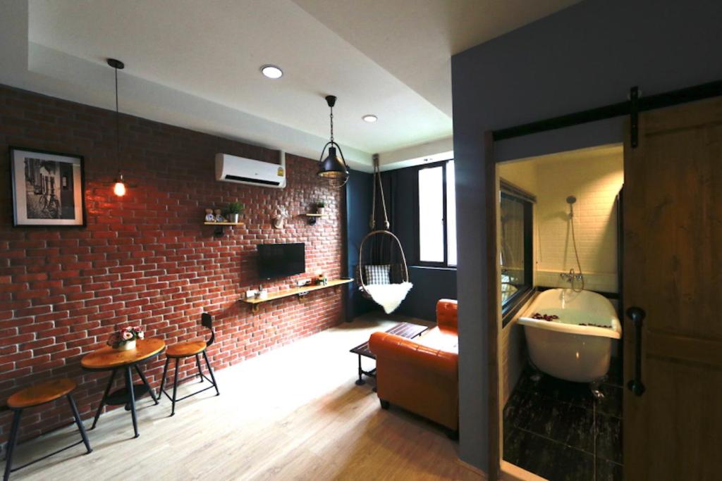 曼谷的住宿－曼谷阿達焦酒店，一间带砖墙和沙发的客厅