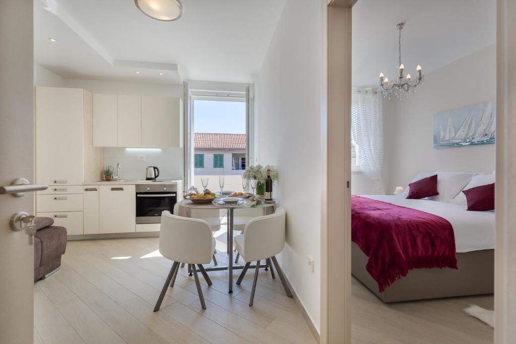 a bedroom with a bed and a table and chairs at Central Boutique Apartments with balconies, in walking distance to the sea in Zadar