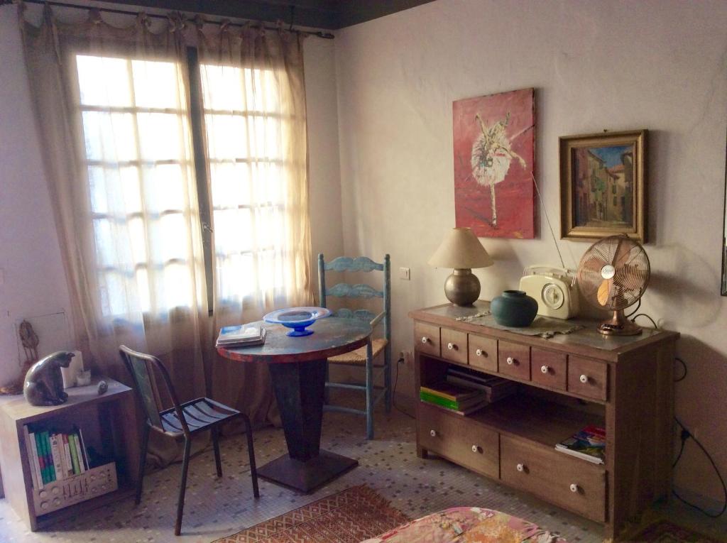 サン・カンタン・ラ・ポテュリにあるNid d'Artisteのデスク、テーブル、テーブル、椅子が備わる客室です。