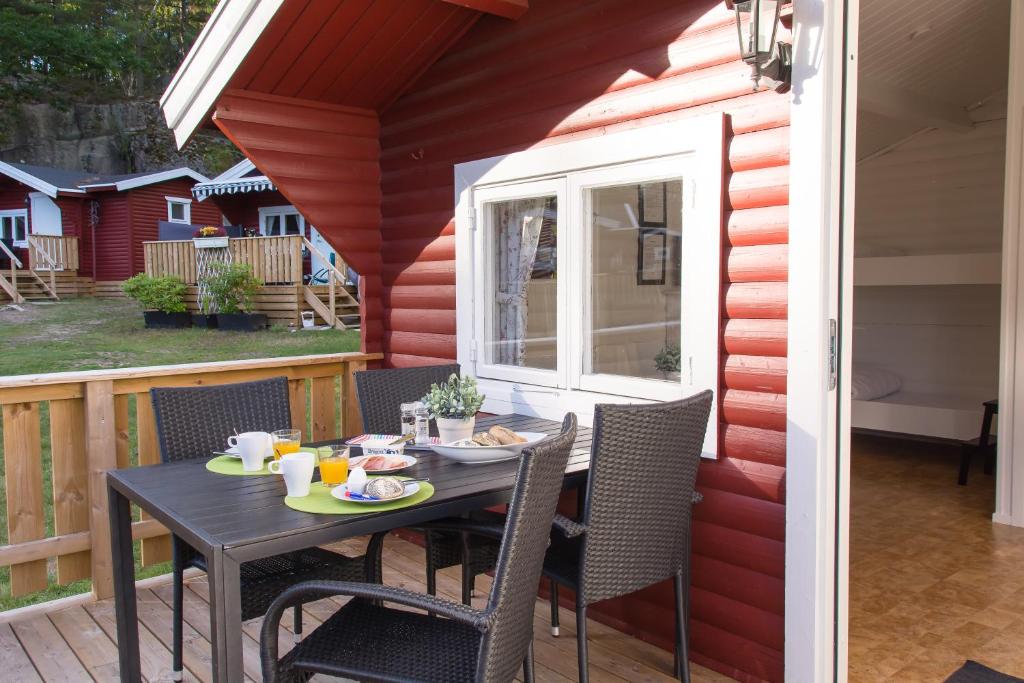 a table and chairs on a patio with a window at Seläter Camping in Strömstad