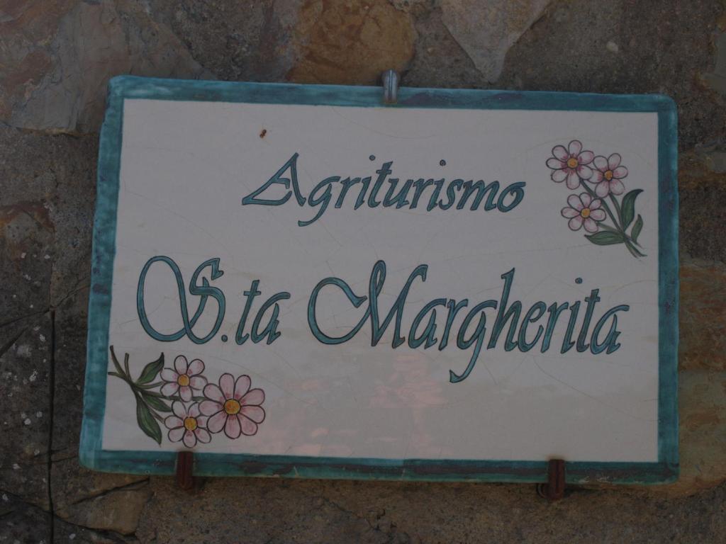 um sinal no lado de uma parede em Santa Margherita em Castiglione dʼOrcia