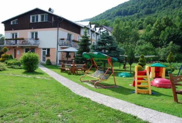 a yard with playground equipment in front of a house at Penzión Šuštiak in Terchová