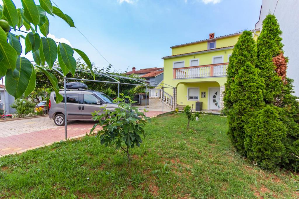 a van parked in front of a yellow house at Apartment Vilic in Pula